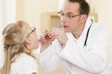 Arzt untersucht Hals kleiner Patientin